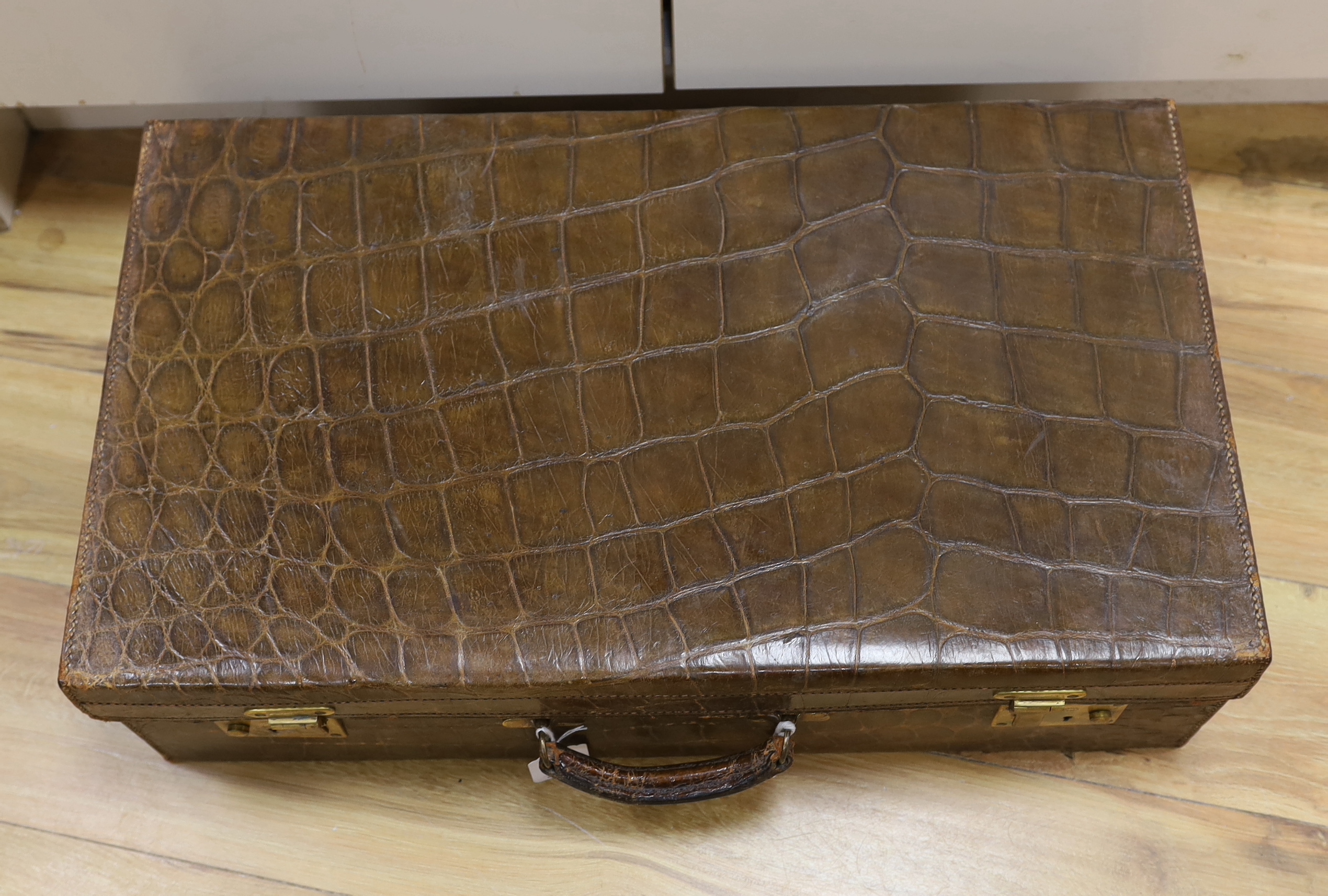 A Vintage 1930’s crocodile skin travelling case, 65cm wide